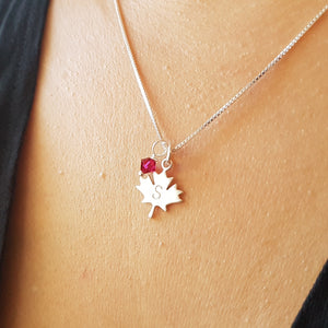 woman wearing sterling silver maple leaf initial necklace with swarovski birthstone